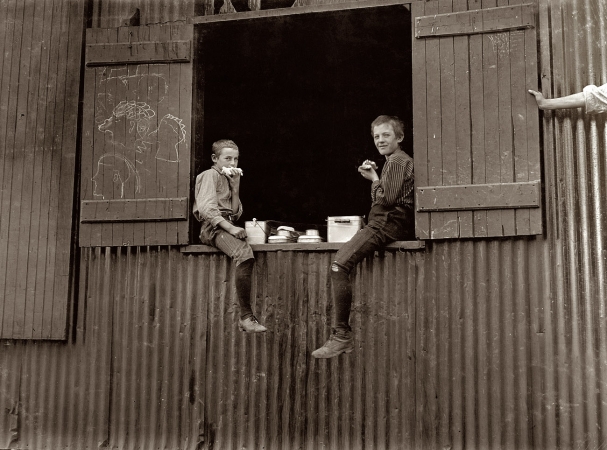 Photo showing: Lunch Break -- October 1908. Lunch time at the Economy Glass Works in Morgantown, W. Va. Plenty more like this inside.