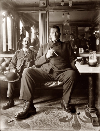 Photo showing: Living Large -- Giant. Big man enjoying a cigar and glass of beer in a New York tavern circa 1908.