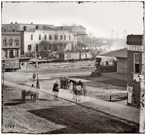 Photo showing: Sherman in Atlanta -- 1864. Soldiers on boxcars next to offices of the Atlanta Intelligencer during the city's occupation by General Sherman.