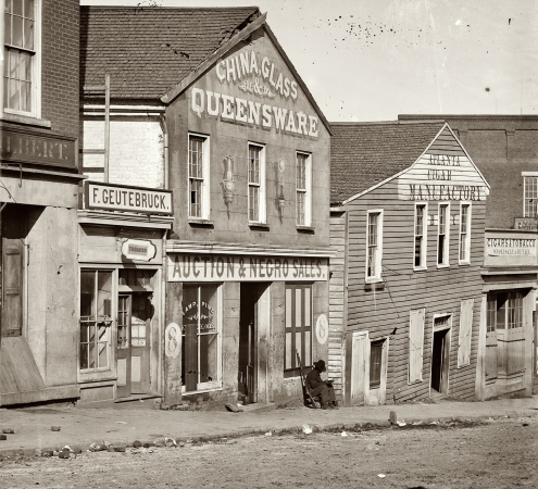 Photo showing: Atlanta Slave Auction House -- Black Union soldier posted at a slave auction house during Gen. Sherman's occupation, 1864.