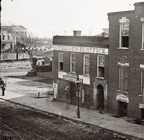 Photo showing: Ghosts of Atlanta -- The War in the West. 1864 photo by George N. Barnard. The Atlanta Intelligencer newspaper office by the railroad depot.