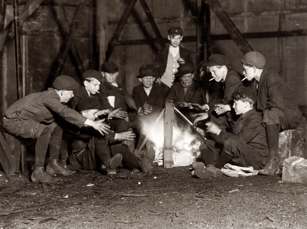 Photo showing: Our Gang: 1910 -- May 7, 1910. St. Louis, Missouri. Jefferson Street Gang of newsboys over campfire in corner lot behind bill-board. 