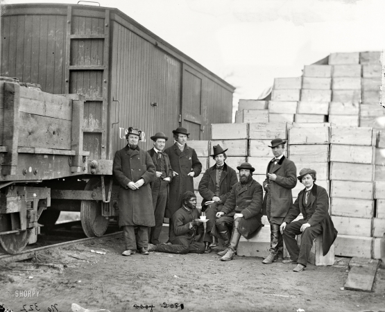 Photo showing: The Great Emancipators -- Aquia Creek Landing, Virginia, 1863. Federal Army. Clerks of the Commissary Depot by railroad car and packing cases.
