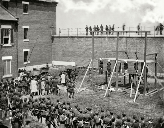 Photo showing: Hanging Together: 1865 -- July 7, 1865. Washington, D.C. Hanging hooded bodies of the four conspirators; crowd departing.