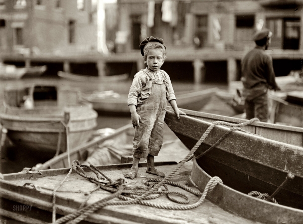 Photo showing: Sea Urchin -- October 1909. Boston, Massachusetts. Truant hanging around boats in the harbor during school hours.