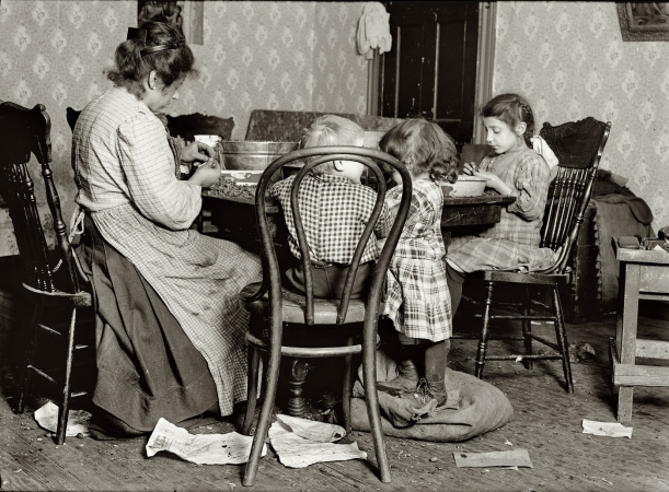 Photo showing: The Libertines -- New York, December 1911. Mrs. Lucy Libertine and family: Johnnie, 4 years old;
Mary, 6 years; Millie, 9 years, picking nuts in the basement tenement, 143 Hudson Street.