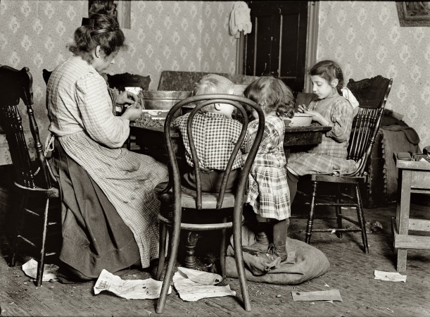 Photo showing: The Libertines -- New York, December 1911. Mrs. Lucy Libertine and family: Johnnie, 4 years old;
Mary, 6 years; Millie, 9 years, picking nuts in the basement tenement, 143 Hudson Street.