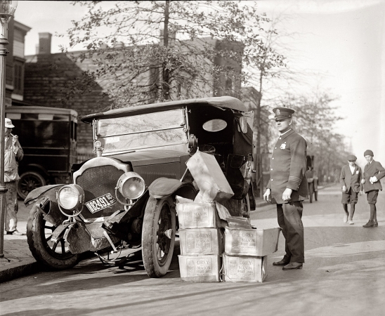 Photo showing: Bootlegger Bust -- November 16, 1922. Cases of moonshine next to wreck of bootlegger's car in Washington, D.C.