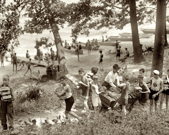 Photo showing: The Loaves of Summer -- Summer 1923. Vicinity of Washington, D.C. Boys carrying loaves of bread from wagons near beach.