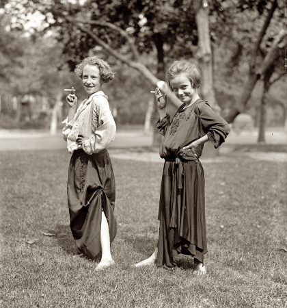 Photo showing: Starting Young -- August 31, 1923. Girls dressed as adults, posing with cigarettes.