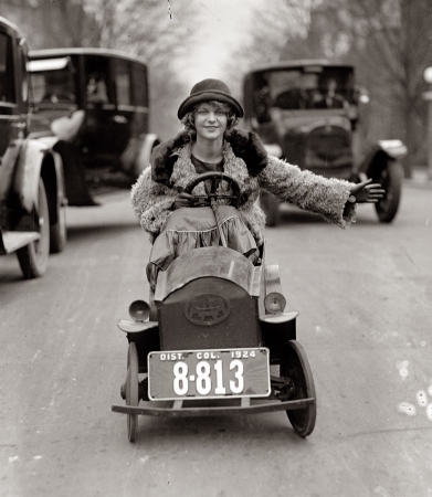 Photo showing: Traffic-Stopper -- January 29, 1924. Miss Mary Bay likes her car because it is
easy to park. Miss Bay is shown braving the traffic of Washington. 