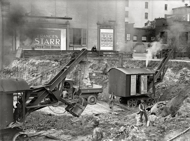 Photo showing: Steam Shovel Show -- Washington, D.C., April 1918. Downtown construction. Excavation with a theatrical backdrop.