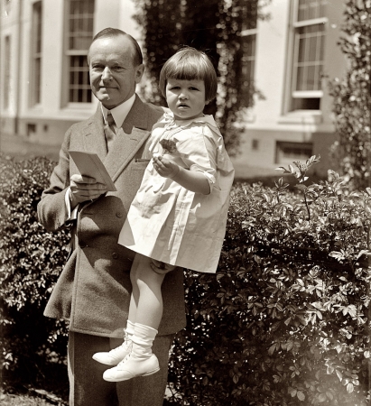 Photo showing: Smiling Cal -- April 28, 1927. Tiny tot gives President Coolidge flood relief contribution.