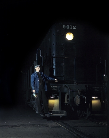 Photo showing: Always Be Careful -- Riding the footboard of an Illinois Central diesel switch engine, South Water Street freight terminal, Chicago. May 1943.