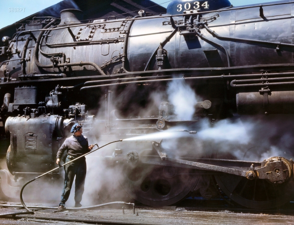 Photo showing: Steam Bath: 1943 -- Viola Sievers, Chicago & North Western wiper, giving a giant 'H' class locomotive a bath of live steam at Clinton, Iowa.