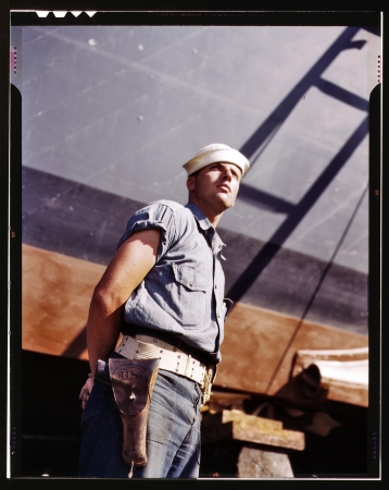 Photo showing: The Sentinel -- Coast Guardsman standing watch over 78-foot torpedo boat. Higgins Industries Inc., New Orleans, July 1942.