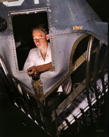 Photo showing: Nose Job -- August 1942. NYA trainee working inside the nose of a PBY, Corpus Christi Naval Air Base, Texas.