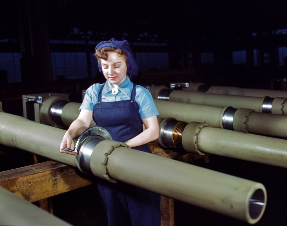 Photo showing: Measuring Howitzers -- Mrs. Mary Betchner measuring 105mm howitzers at the Milwaukee plant of the Chain Belt Company, February 1943.