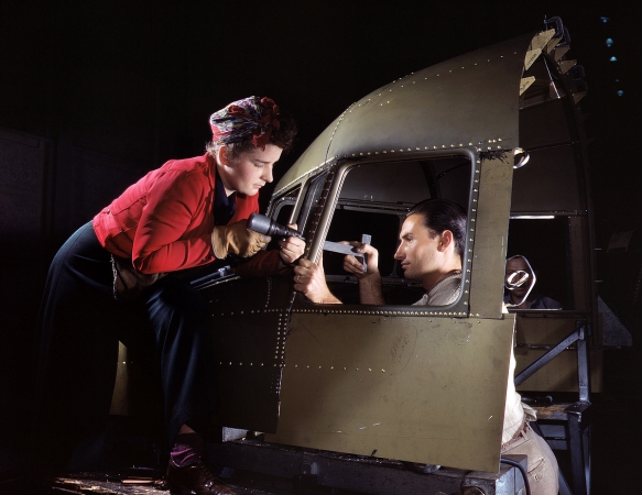 Photo showing: We Met at Work -- October 1942. Riveting team at the Douglas Aircraft plant, Long Beach, Calif., working on a C-47 heavy transport plane.
