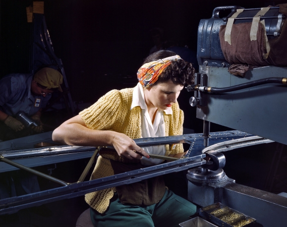 Photo showing: B-17 Betty: 1942 -- Long Beach, California. Girl riveting machine operator at Douglas Aircraft joins sections of wing ribs for B-17F bomber.