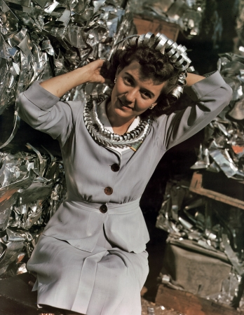 Photo showing: Aluminum Curls -- October 1942. Office employee at Douglas Aircraft, Long Beach,with aluminum scraps collected at the plant.
