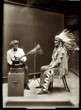 Photo showing: Song Catcher: 1916 -- Mountain Chief of Piegan Blackfeet making phonographic record at Smithsonian, with ethnologist Frances Densmore.