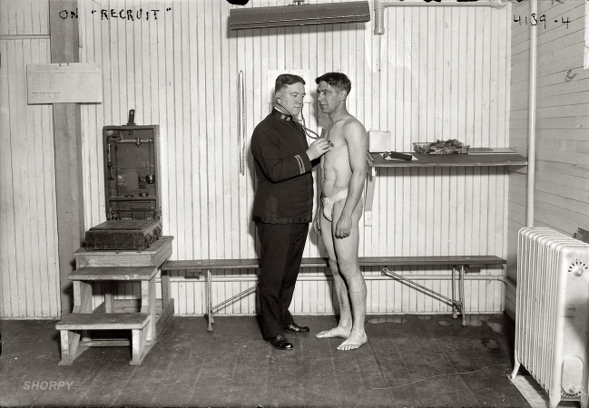 Photo showing: I Feel a Draft -- New York, 1917. Examining a potential sailor aboard the landship Recruit.