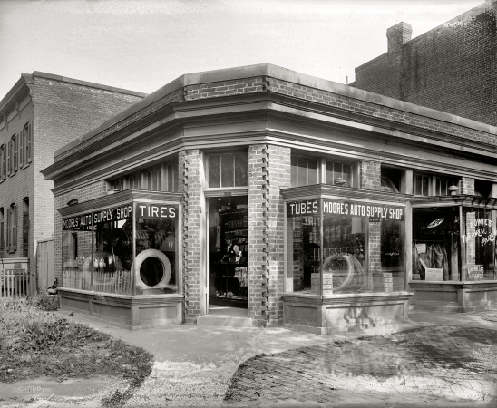 Photo showing: Auto Supply Corner -- Washington, D.C., circa 1920. Moore's Auto Supply Shop, 20th & K streets N.W.