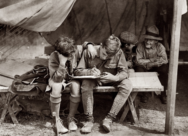 Photo showing: Hello Muddah -- Hunter's Island, New York, circa 1912. Boy Scouts at Hunter's Island. Writing to the folks at home.
