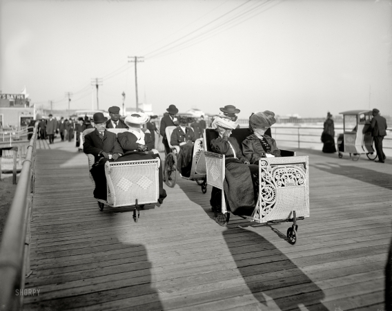 Photo showing: A Fast Crowd. -- Atlantic City, New Jersey, circa 1905. Rolling chairs on the Boardwalk.