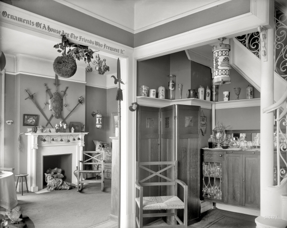Photo showing: Ornaments of a House: 1915 -- Hallway with liquor cabinet and living room decorated with mistletoe ball and Christmas gnome by fireplace.