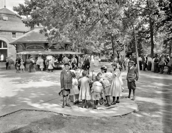 Photo showing: Whistle-Wetting Whelps -- Around a bubbling cup, Lincoln Park, Chicago circa 1910.