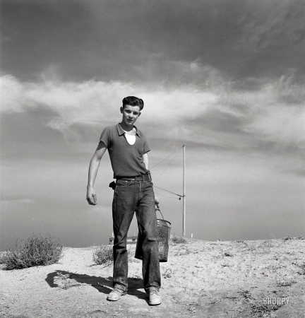 Photo showing: Dazey Boy: 1939 -- Dazey farm. Seventeen year old boy going to feed the pigs. Homedale district, Malheur County, Oregon.