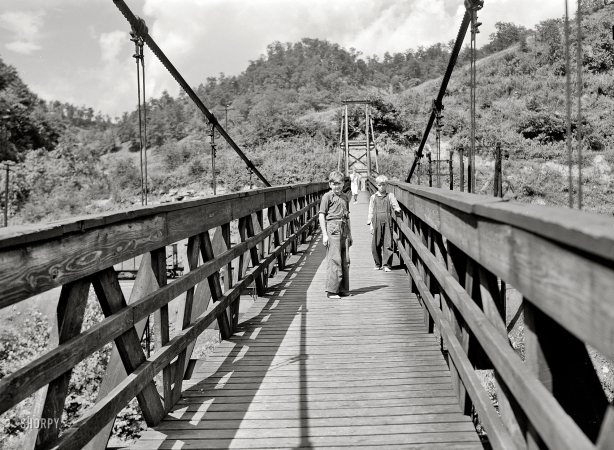Photo showing: Hazard Bridge -- July 1940. Hazard, Kentucky. Miners' children crossing swinging bridge from their homes into town.
