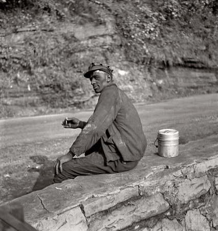 Photo showing: W.Va. Coal Miner -- September 1938. Capels, West Virginia. Coal miner waiting for lift home.