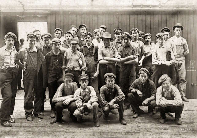 Photo showing: Tough Tomatoes -- August 1908. Noon hour in an Indianapolis tomato cannery. Young fellows in front of boxcar.