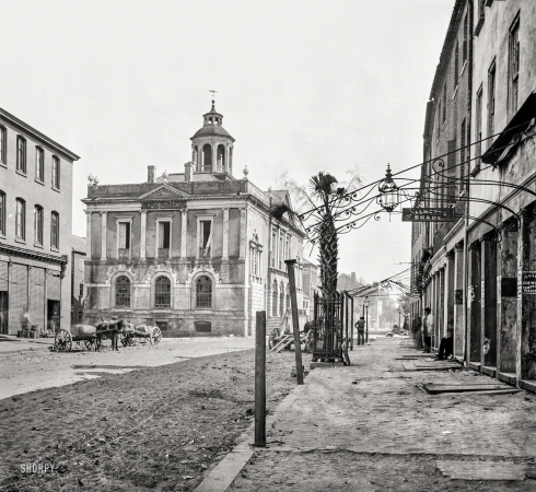 Photo showing: Palmetto Shade -- April 1865. Charleston, South Carolina. Post Office (old Exchange and Custom
House), East Bay Street, showing the only Palmetto tree there is in the city.