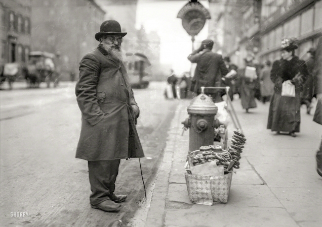 Photo showing: Mr. Pretzel -- New York circa 1910. Seller of pretzels, Sixth Avenue.