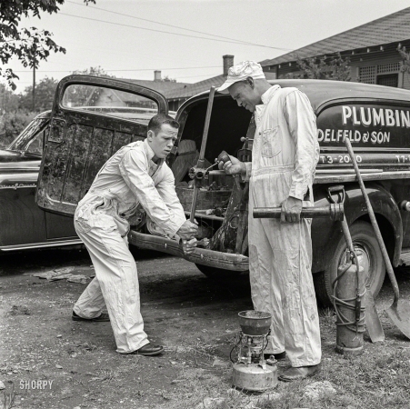 Photo showing: High School Hero -- May 1954. High school football player Paul Delfeld, 17, of North Dallas, Texas, helping father at plumbing business.