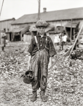 Photo showing: Raggedy Henry -- February 1912. Henry, 10-year-old oyster shucker who does five pots</br />
of oysters a day. Maggioni Canning Co., Port Royal, South Carolina.