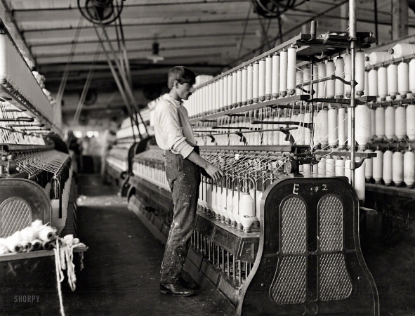 Photo showing: Big and Tall -- December 1908. Catawba Cotton Mills. Newton, N.C. It seems a pity that
some of the spinning frames are so large that the children cannot operate them. 