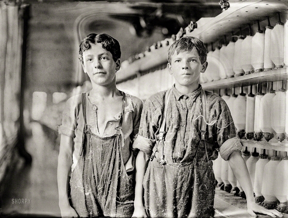 Photo showing: Back-Ropers -- May 1909. Leopold Daigneau and Arsene Lussier, 'back-roping boys' in
the mule-spinning room at Chace Cotton Mill, Burlington, Vermont.