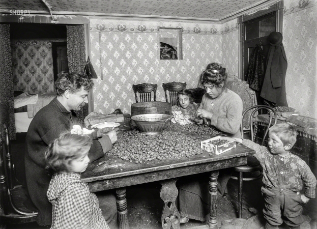 Photo showing: Pecans of Wrath -- December 1911. Picking nuts in dirty basement tenement, 143 Hudson Street, New York.