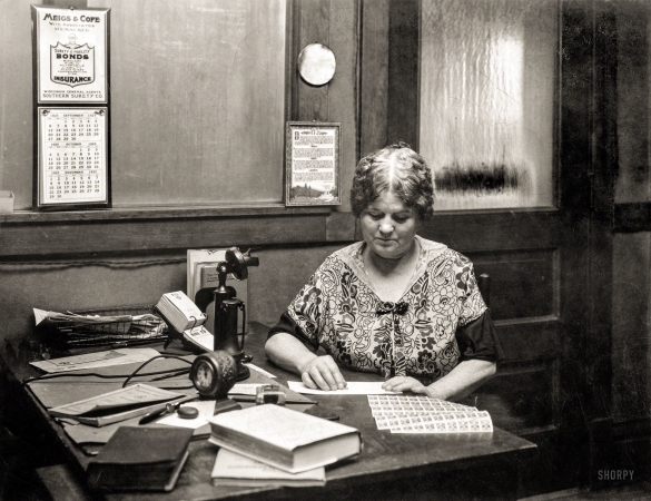 Photo showing: A Case of the Mondays -- Oct. 19, 1925. Woman at office desk.