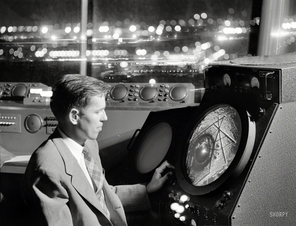 Photo showing: On the Radar -- 1952. Man in an airport control tower looking at radar screen.