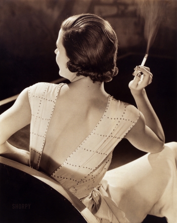 Photo showing: Back in Fashion -- Ca. 1932. Glamorous woman holding a cigarette.