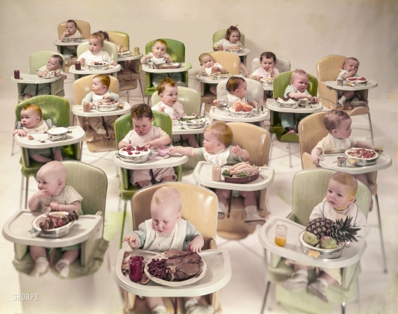 Photo showing: Oh Grow Up -- February 26, 1954. Large group of infants in high chairs with various adult foods on their trays.