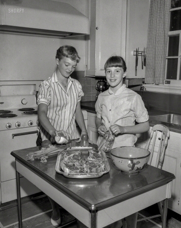 Photo showing: Broil Meats Girl -- Circa 1956. Girls in kitchen with steaks.