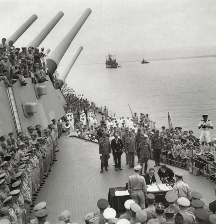 Photo showing: Japan Surrenders -- Sept. 2, 1945. Japanese foreign minister Mamoru Shigemitsu signing the document of surrender aboard the</br />
U.S. battleship Missouri in Tokyo Bay as Gen. Douglas MacArthur and members of the Allied delegations watch. 