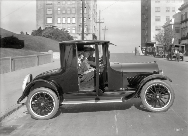 Photo showing: The In-Crowd -- San Francisco circa 1920. Oldsmobile coupe on Gough Street at Lafayette Park.
